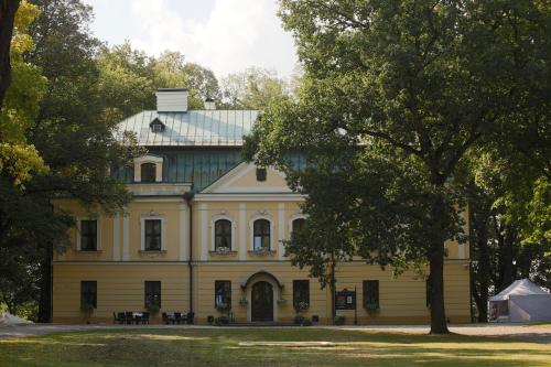 RybnaPalac w Rybnej的蓝色屋顶的大型黄色房屋