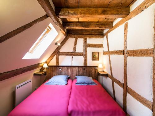 希伯维列Gîtes Strengbach的阁楼卧室配有粉红色的床