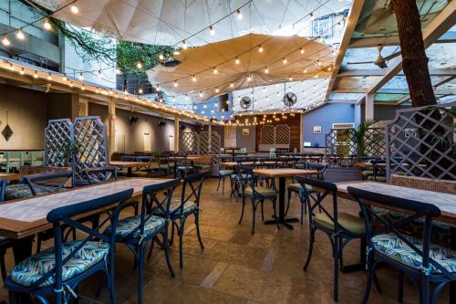 孟买Le Sutra Hotel, Khar, Mumbai的配有木桌和椅子的餐厅
