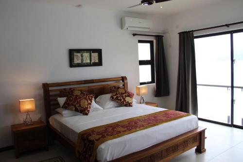 贝尔欧布莱冲浪者湾公寓酒店的一间卧室设有一张床和一个大窗户