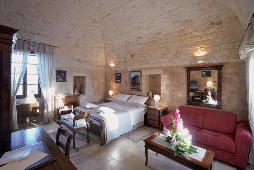 切列梅萨皮卡马塞里亚本尼费西奥豪华乡村民宿的一间卧室配有一张床和一张红色的沙发