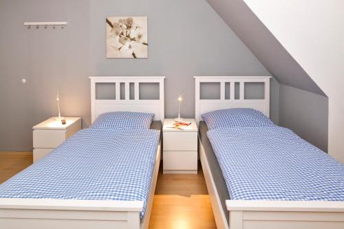 PrisdorfBett4-you Pinneberg - Prisdorf的卧室设有两张蓝色和白色的床