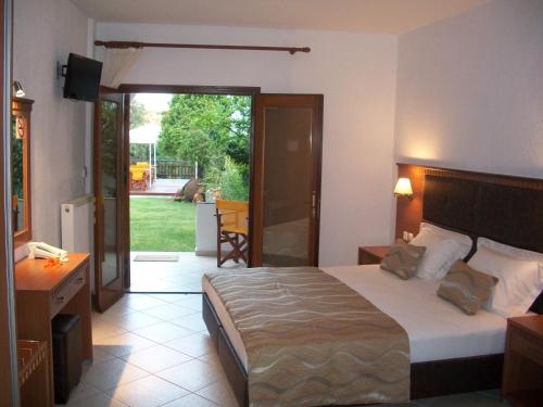欧拉努波利斯斐罗克斯尼娜酒店的一间卧室设有一张床,一扇门通往庭院