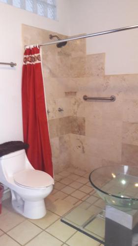恰卡拉卡萨查卡拉酒店的浴室设有卫生间和红色的淋浴帘