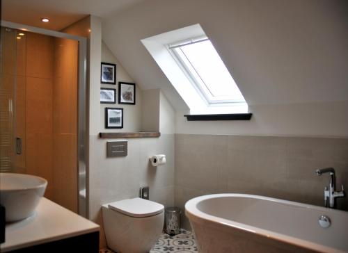 波特里马姆雷德酒店的一间带卫生间、浴缸和天窗的浴室