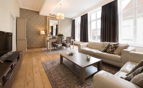 布鲁日三王公寓的客厅配有沙发和桌子