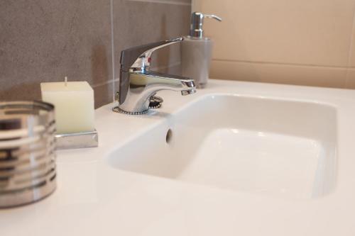 瓦伦西亚瓦伦西亚Pio XII公寓式酒店的浴室设有蜡烛和水龙头的盥洗盆。