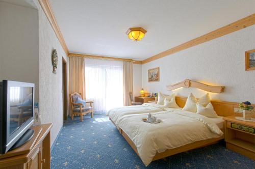 朗根费尔德兰德罗曼酒店的配有一张床和一台平面电视的酒店客房