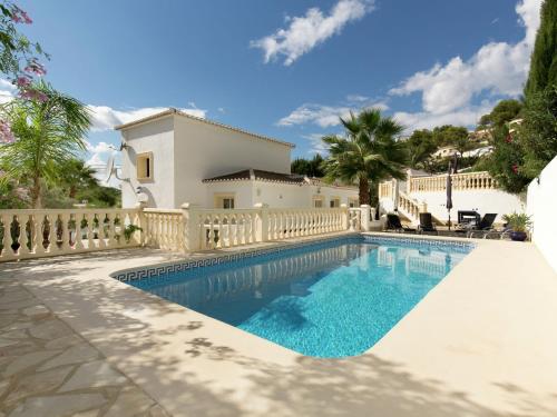 库姆布勒德尔索尔Belvilla by OYO Villa Junique的白色房子前的游泳池