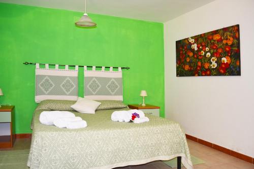 阿尔巴塔克斯Casa Vacanza Porto Frailis già Porto Frailis B&B的绿色卧室,配有带毛巾的床