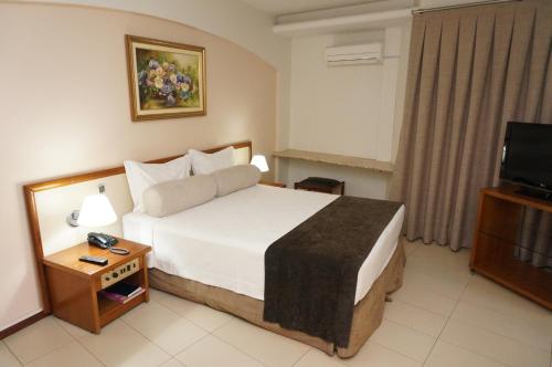 伊通比亚拉Hotel Beira Rio的酒店客房,配有床和电视