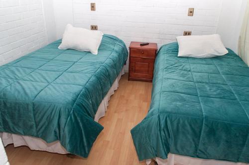 科皮亚波Hotel Altos de Atacama的两张睡床彼此相邻,位于一个房间里
