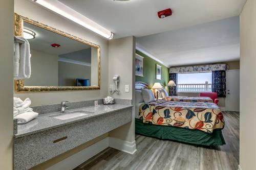 默特尔比奇Beachcomber Inn & Suites的酒店客房设有床、水槽和镜子