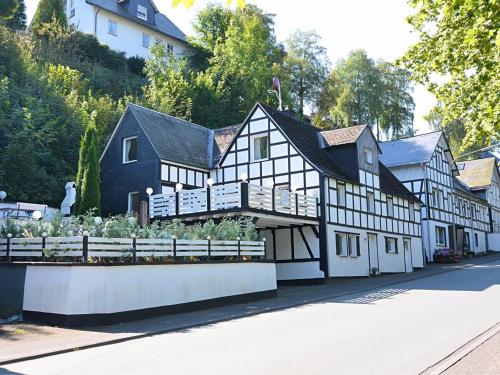 施马伦贝格Holiday home in Schmallenberg near a ski resort的一座黑白的建筑,前面有一个花园