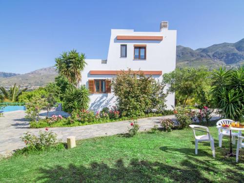 莱弗考基亚Chic Villa in Lefkogia Crete with Swimming Pool的房屋设有1个带桌椅的庭院