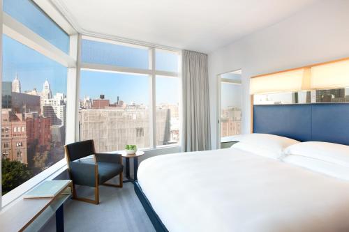 纽约东乡村设计酒店的一间卧室设有一张大床和一个大窗户