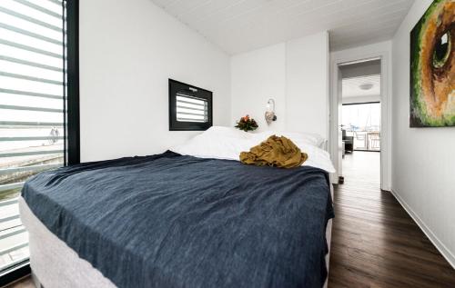 Kollund ØsterskovHausboot FJORDBLIK的一间卧室配有一张带蓝色毯子的床