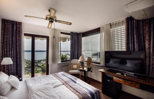 波尔托罗Villa Bellevue Portoroz-Portorose的一间卧室配有一张床和一台平面电视