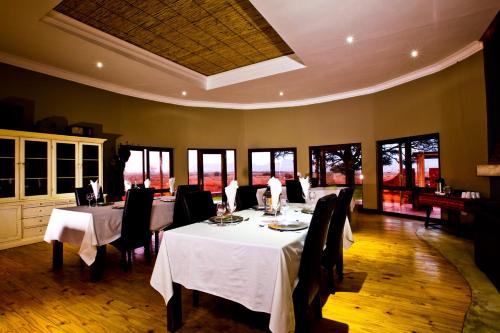 塞斯瑞姆We Kebi Safari Lodge的用餐室设有桌椅和窗户。