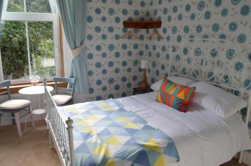 斯特兰拉尔Briar Brae Bed & Breakfast的一间卧室配有一张床、一张桌子和一个窗户。