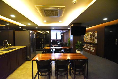 首尔明洞57号旅馆的厨房配有大型木桌和椅子