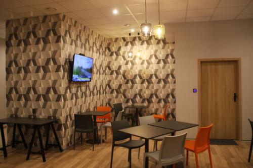 格丁尼亚Hostel City Center Gdynia的一间带桌椅的餐厅以及墙上的电视