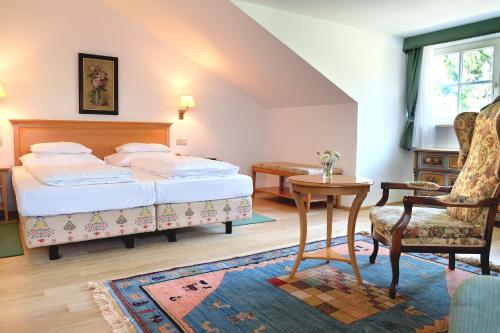 维也纳兰德豪斯弗格奥斯-胡波酒店的一间卧室配有一张床、一把椅子和一张桌子