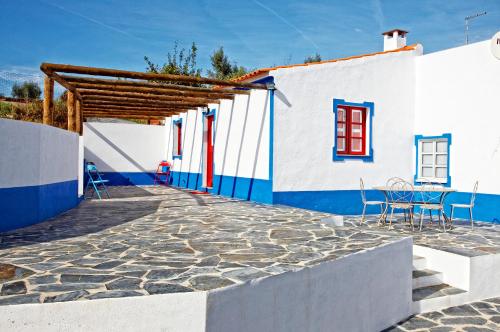 雷根古什-迪蒙萨拉什Casa da Eira的一个带椅子的庭院和一座蓝色和白色的建筑