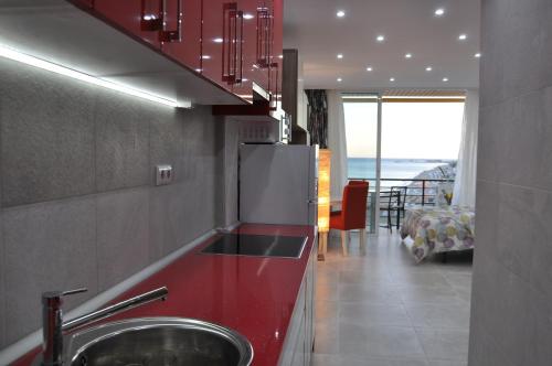 多列毛利诺斯Studio Sea View Terrace的厨房配有水槽和红色台面