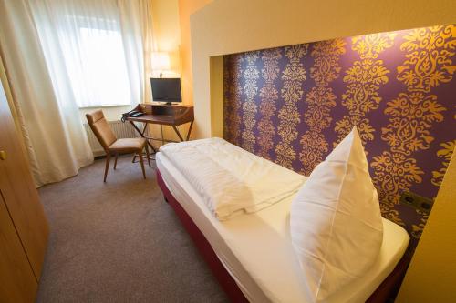 巴特埃姆斯BSW林登巴克友好酒店的酒店客房,配有一张带枕头的床
