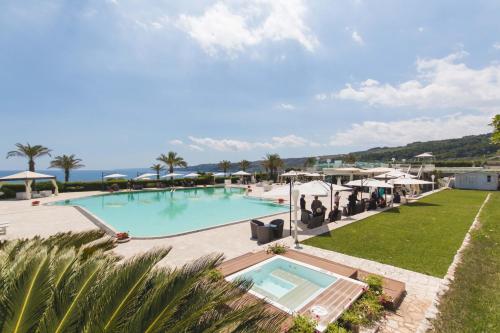 圣凯撒利亚温泉Augustus Resort的享有带遮阳伞的游泳池和大海的景致。