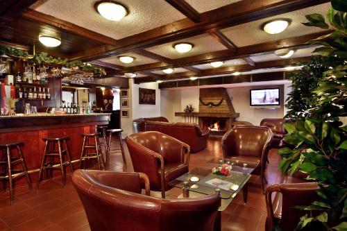 波罗维茨TES弗洛拉公寓式酒店的一间酒吧,里面配有皮椅和桌子