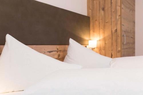 萨姆瑙恩Appartements Garni Alpin Live的卧室配有2个白色枕头