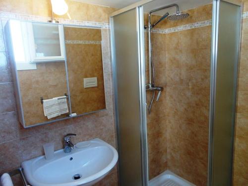 托雷圣乔万尼乌Villetta 3 camere Posto Rosso 155 - Verso Sud的浴室配有盥洗盆和带镜子的淋浴