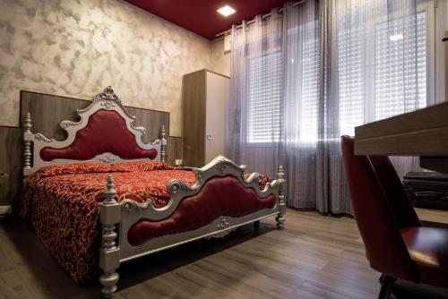 维韦罗内皇家酒店的一间设有红色床的卧室,位于带窗户的房间内