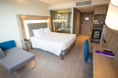 里约热内卢大西洋港诺富特酒店的配有一张床和一把椅子的酒店客房