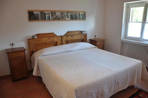 阿科Laghel7 Agritur的一间卧室设有一张床、木制橱柜和窗户。