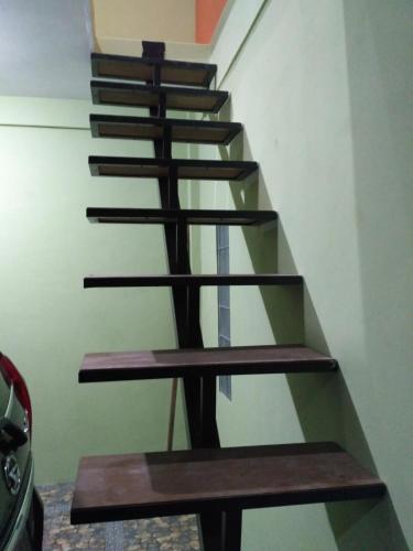 普兰巴南mas Eko Jlatren kost homestay的一座带木台阶的房屋内的楼梯