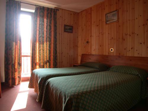 萨奥兹-杜尔克斯Park Hotel Gran Bosco的一间卧室设有两张绿色的床和窗户