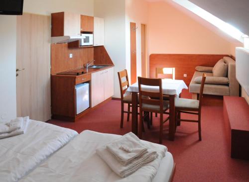 米库洛夫全景旅馆的酒店客房设有厨房、桌子和椅子。