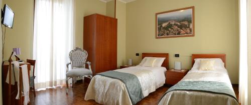 基亚里Hotel La Fenice的一间卧室配有两张床、椅子和一幅画