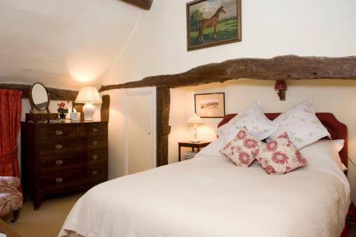 哈尔福德The Old Manor House的卧室配有带枕头和梳妆台的白色床。