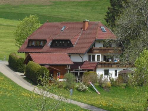 蒂蒂湖-新城Ferienhaus Kaltenbach的绿色田野上一座红色屋顶的房子