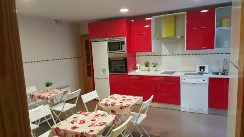 阿维拉唐迭戈旅馆的厨房配有红色橱柜和桌椅