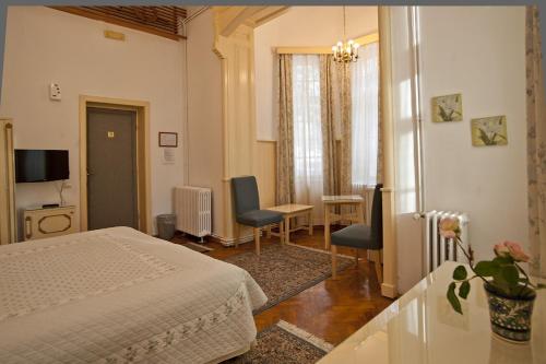 锡纳亚维拉卡梅利亚酒店的卧室配有一张床和一张桌子及椅子
