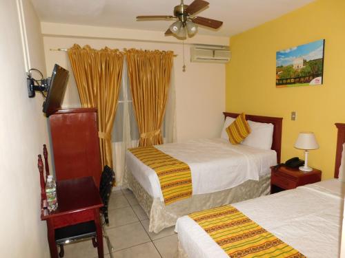 圣萨尔瓦多圣何塞旅馆的酒店客房设有两张床和窗户。
