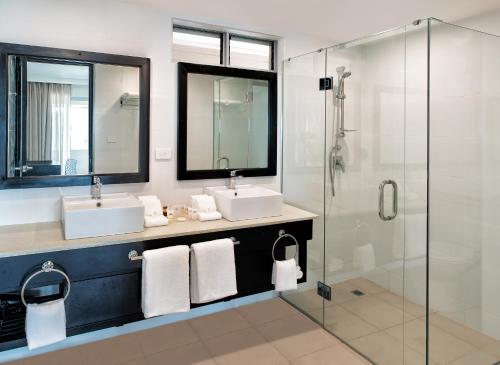 努库阿洛法塔诺阿国际日期变更线酒店 的一间带两个水槽和玻璃淋浴间的浴室