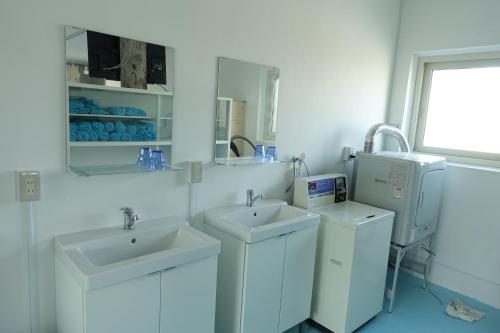 Niijimamura纳布拉旅舍的白色的浴室设有2个水槽和1台洗衣机。