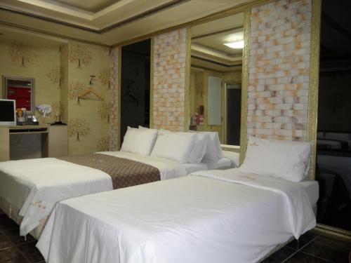仁川市蔚蓝松岛酒店的配有白色床单的酒店客房内的两张床