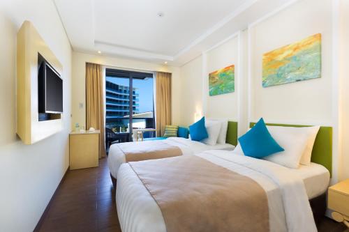 长滩岛长滩岛新海岸萨沃伊酒店的酒店客房设有两张床和电视。